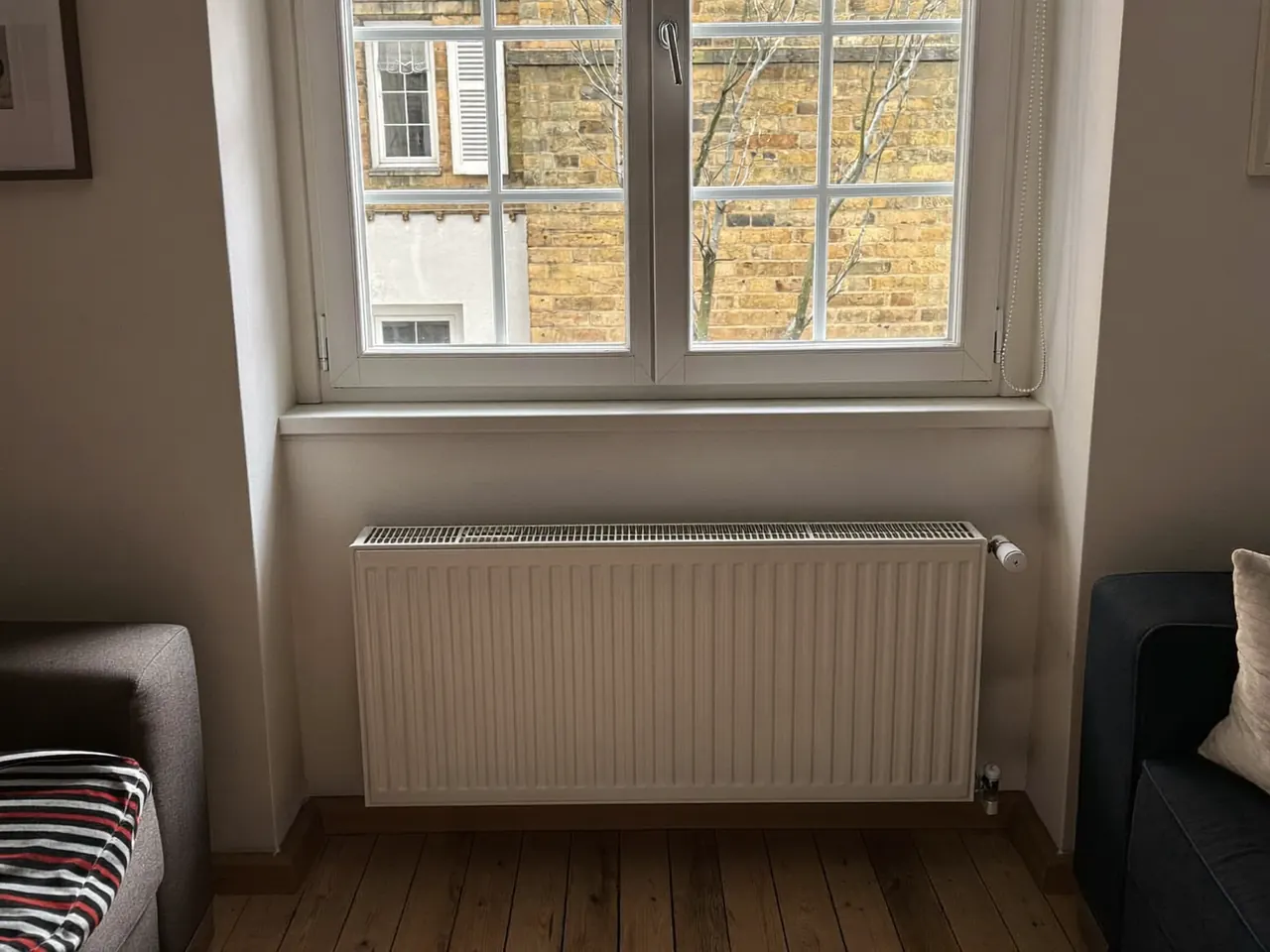 Warm living room with a radiator beside a newly fitted double-glazed window