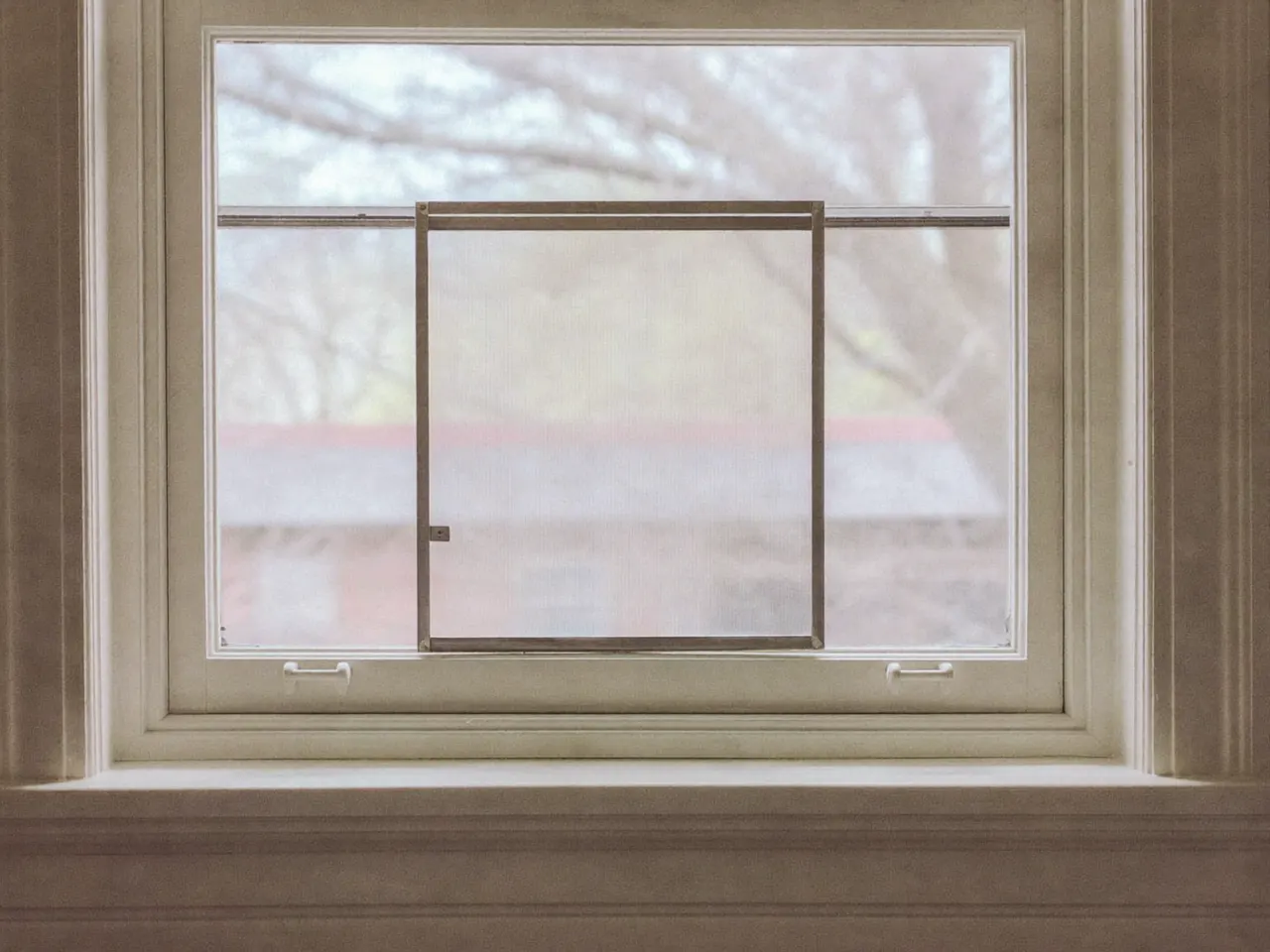 Slim secondary glazing panel fitted inside the reveal of an original timber sash window